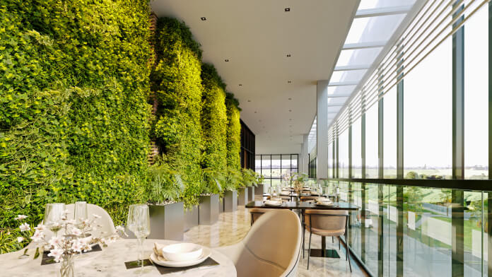Terraço do Bistrô com parede verde e vista para a cidade.